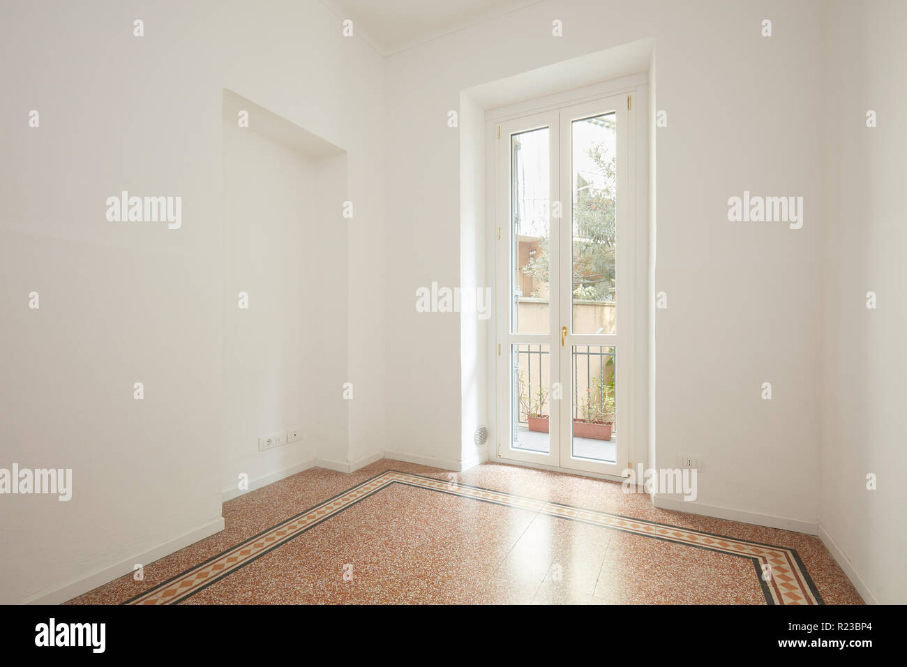 Empty, white living room with large window in a renovated apartment Stock Photo
