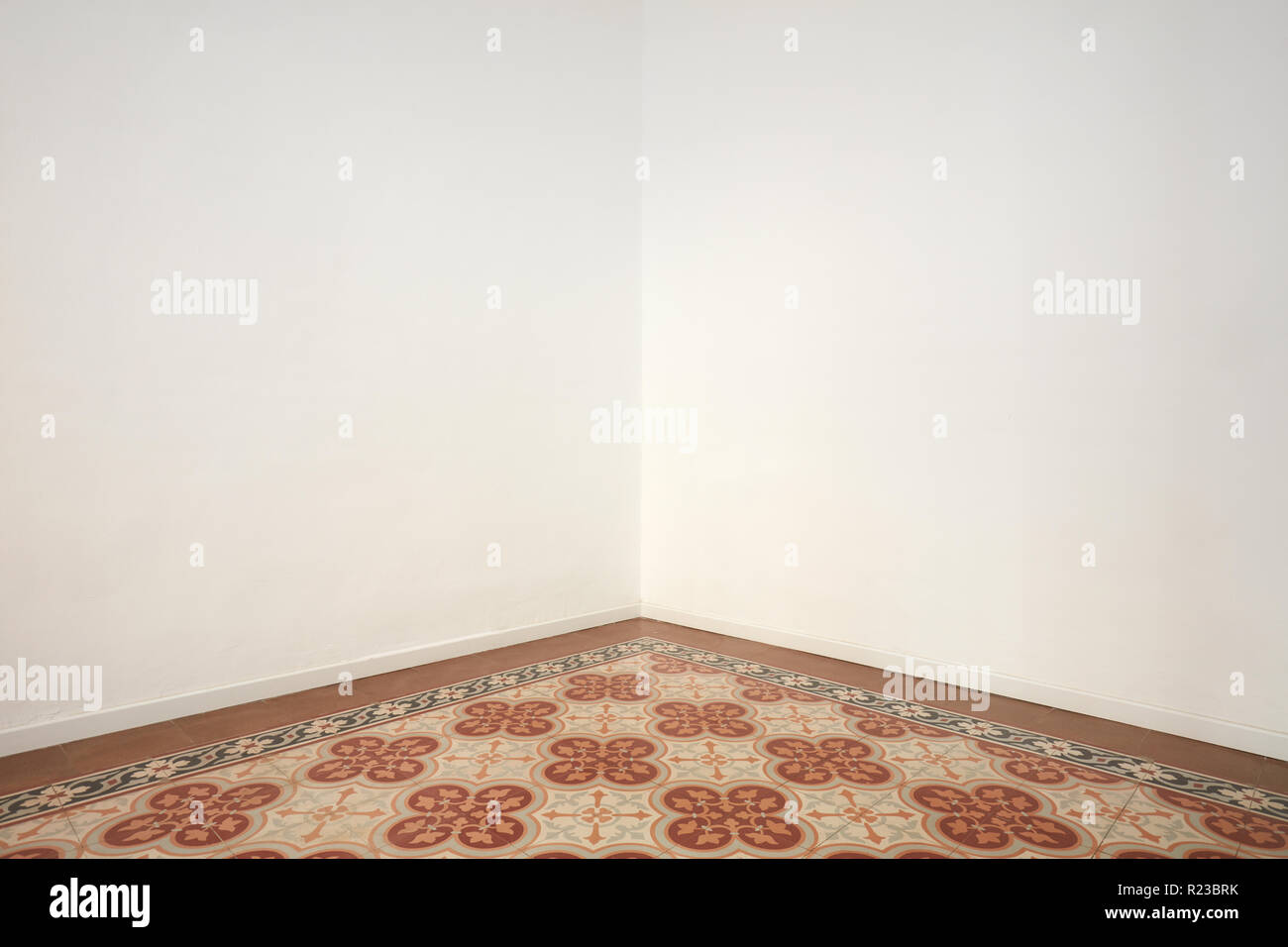 Empty room corner with blank white walls and floral decorated floor Stock Photo