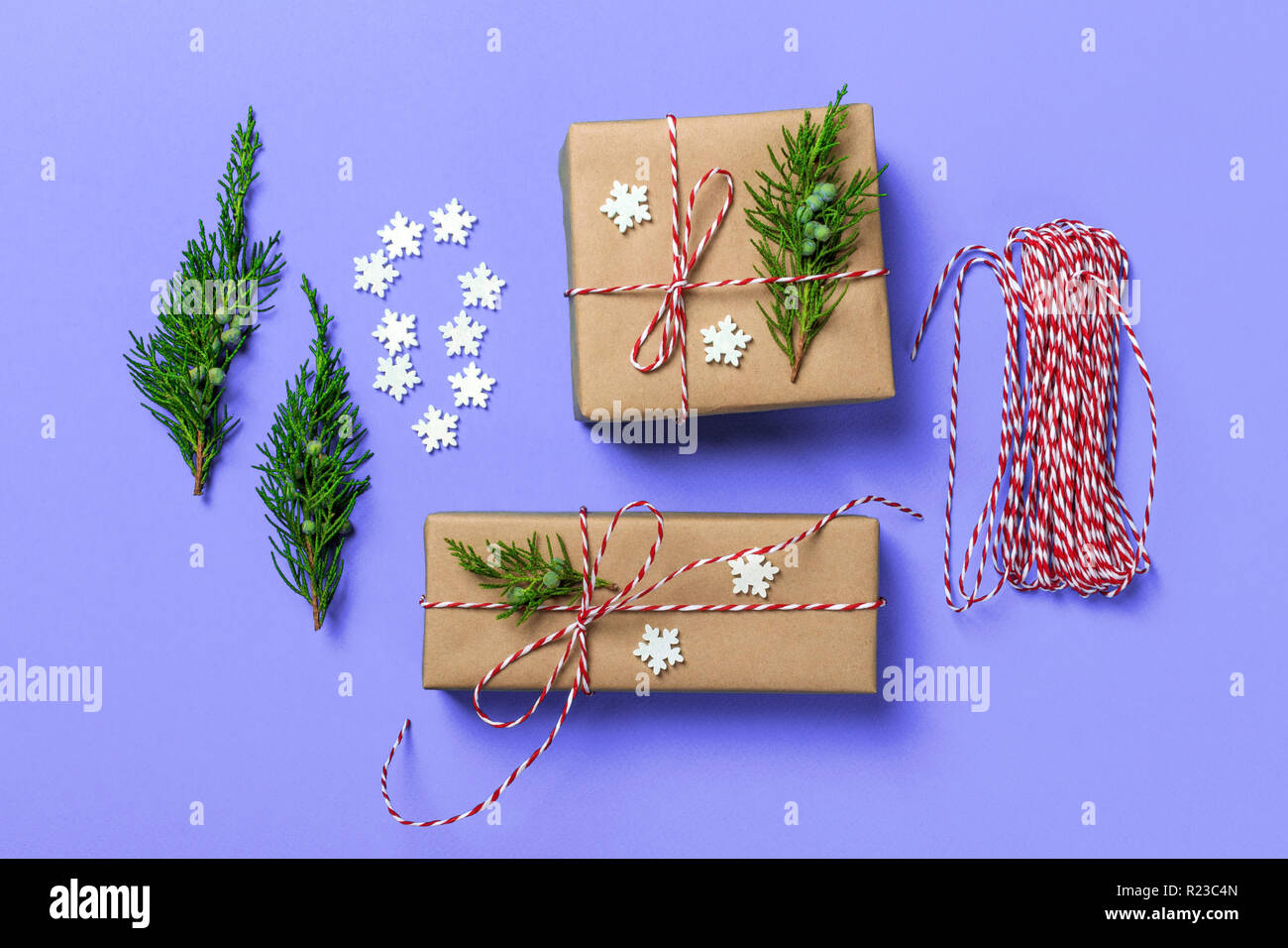 Creative hobby. Gift wrapping. Packaging modern christmas present boxes in stylish blue paper with satin red ribbon. Stock Photo