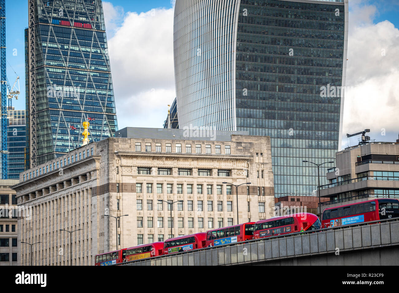 NOVEMBER 13, 2018, London, United Kingdom : Iconic new red London double decker passenger buses on London Bridge feat. Famous Office Buildings Stock Photo