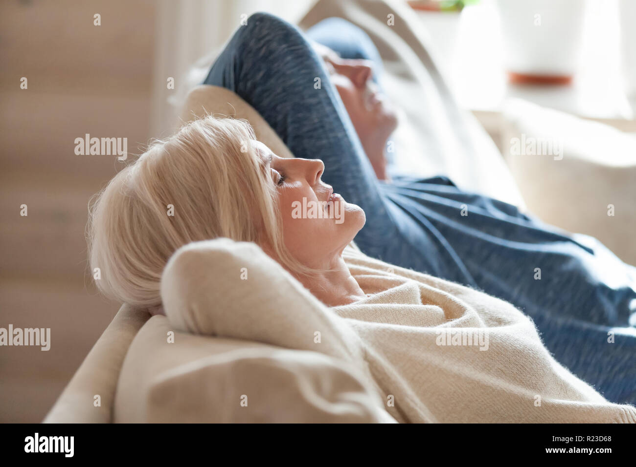 Close up of peaceful aged couple lying with eyes closed relaxing on