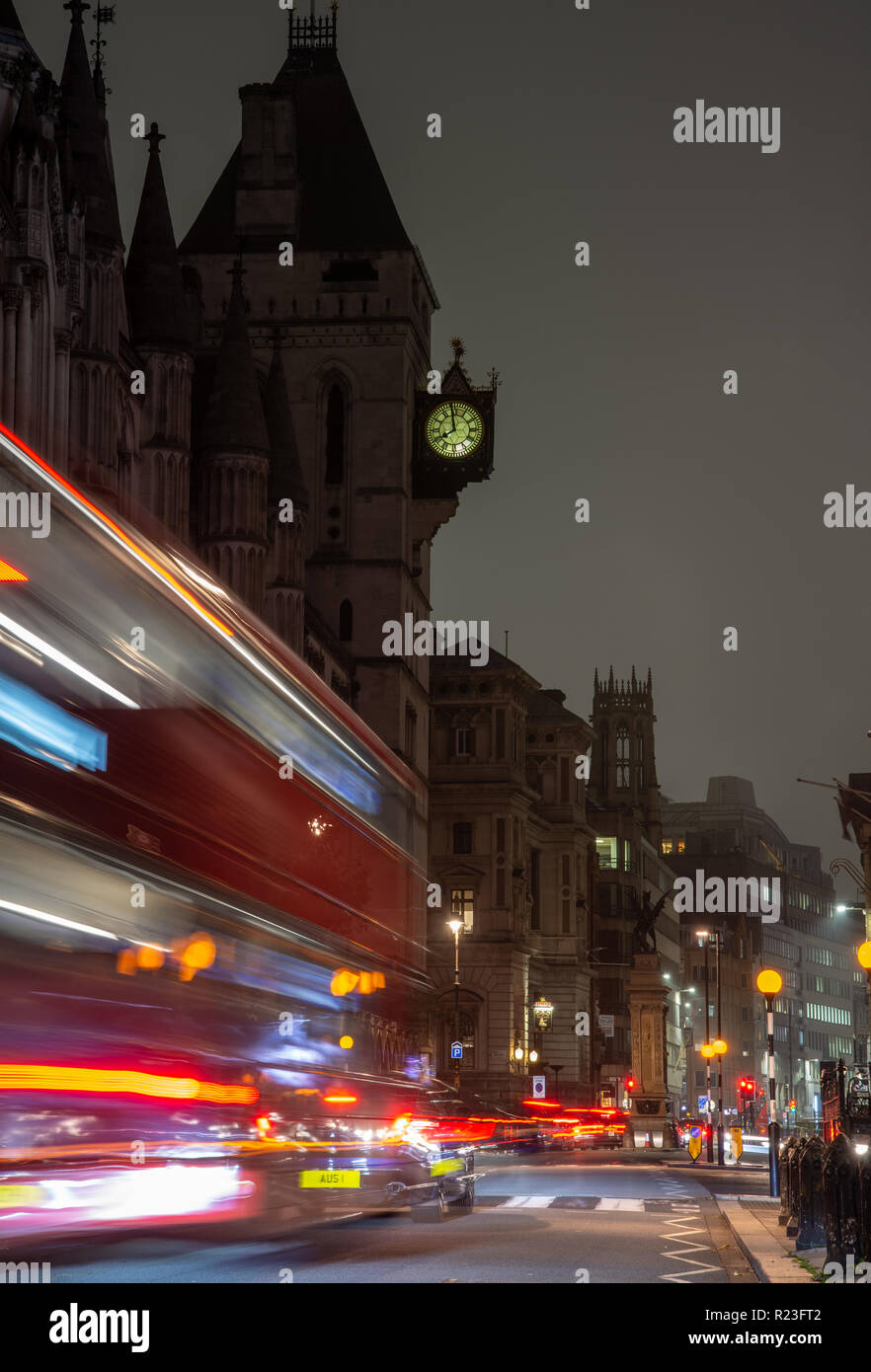 London, England, UK - October 15, 2018: A red double-decker bus leaves light trails as it moves along Fleet Street outside the Royal Courts of Justice Stock Photo