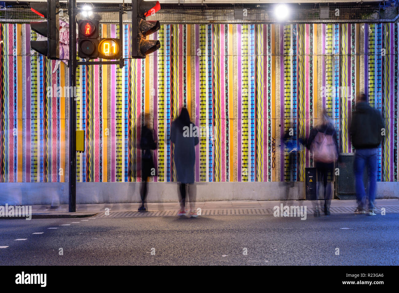London, England, UK - October 7, 2018: Pedestrians cross Ladbroke Grove road at a pelican crossing beneath the Hammersmith and City London Underground Stock Photo