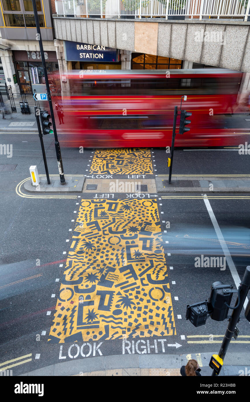 London, England, UK - September 10, 2018: Traffic passes through a junction at Barbican in London, passing a pedestrian crossing painted with jaunty p Stock Photo