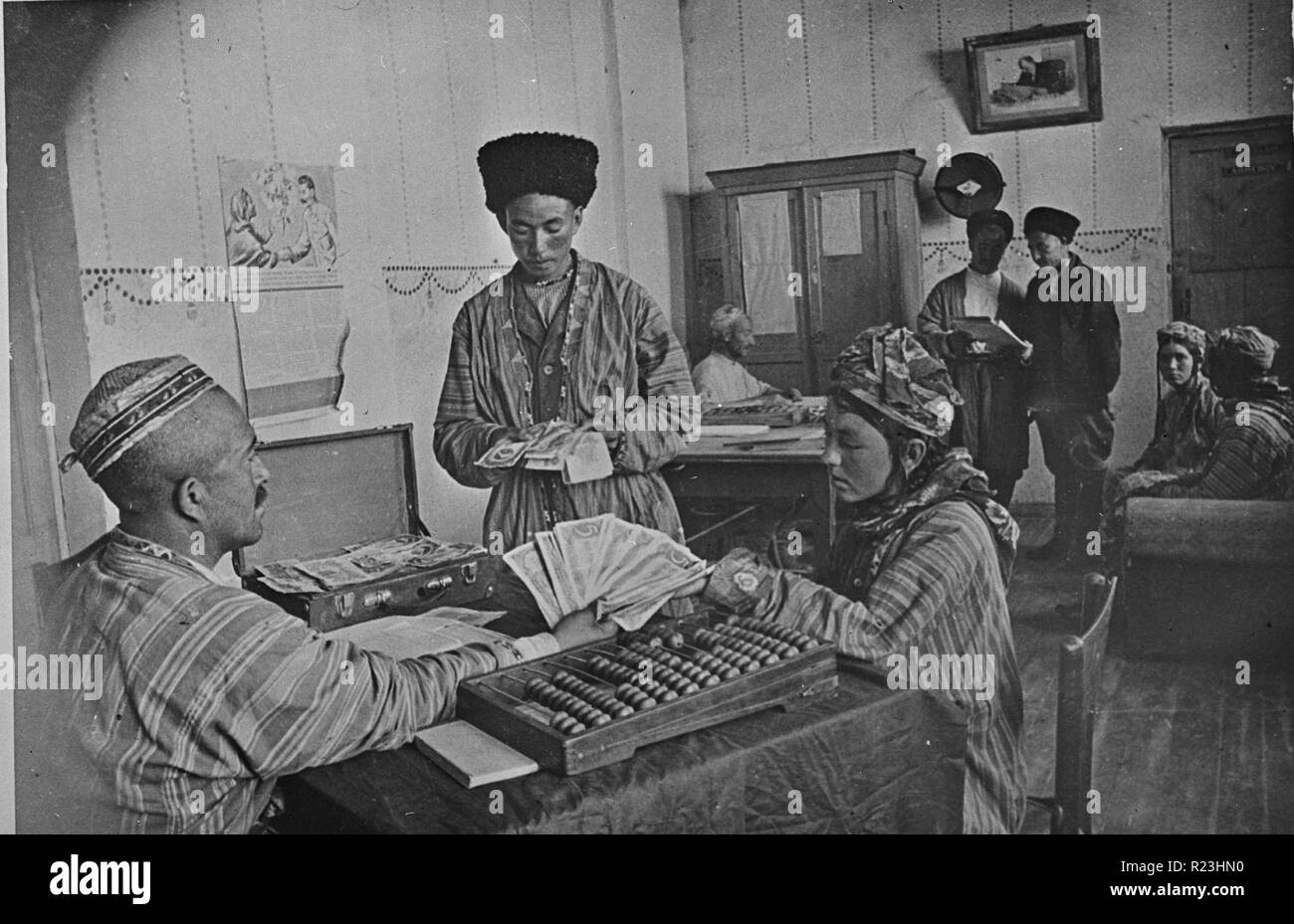 Turkmenian collective farmers receiving part of their yearly income from the profits of the farm in the farm administration office in the USSR (Union of Soviet Socialist Republics) Between 1930 and 1940 Stock Photo