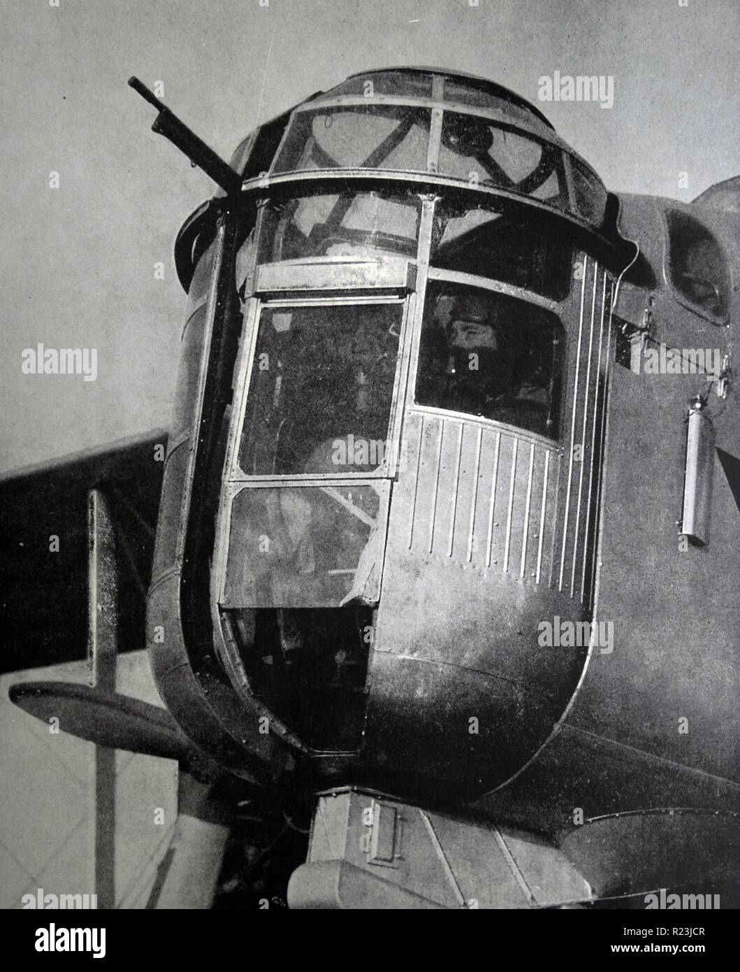 Photograph of a gunner in the 'Glass' house of the Over stand bomber. The glass house is located at the nose of the of the plane. Dated 1939 Stock Photo