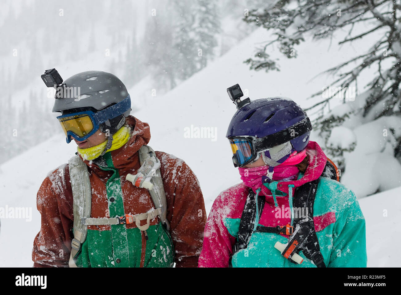 portrait of a couple of snowboarders wearing helmets in the snow