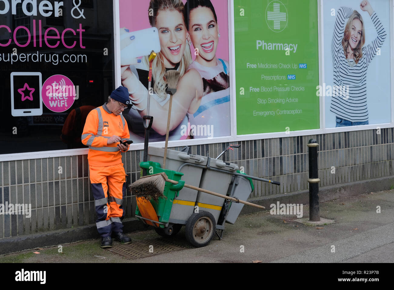 A road sweeper checking his phone. Stock Photo