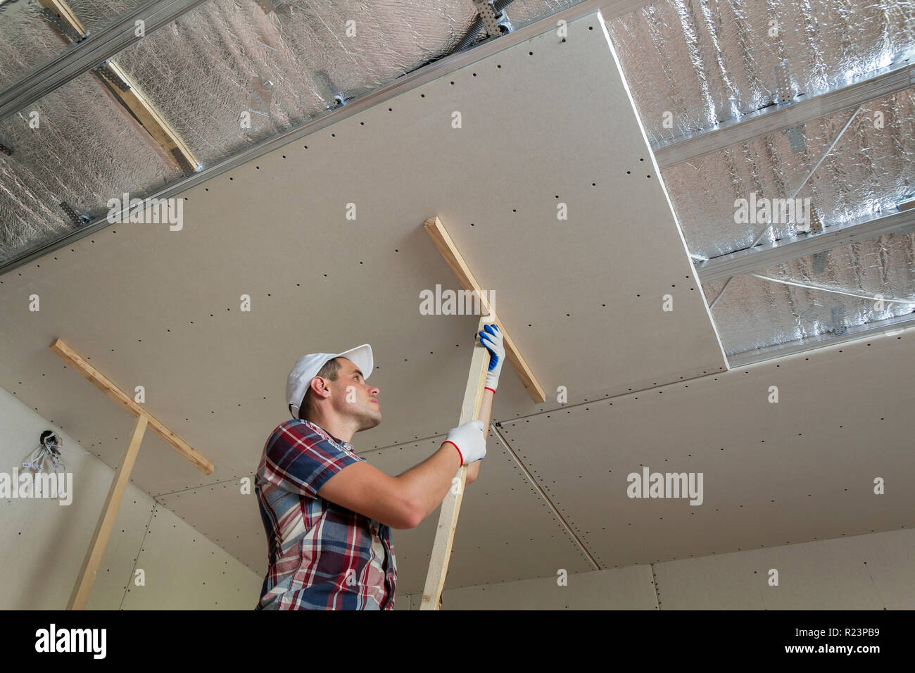 Young Worker In Protection Work Gloves Fixing Wooden Holders For