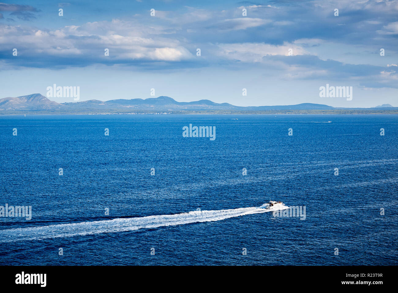 Seascape with a speedboat and Menorca Island in background, Spain. Stock Photo