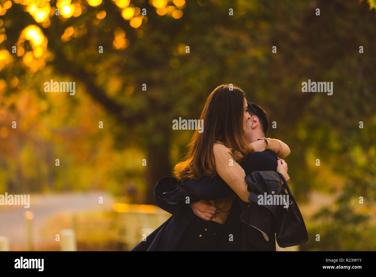 Young couple hugging and kissing at the park Stock Photo - Alamy