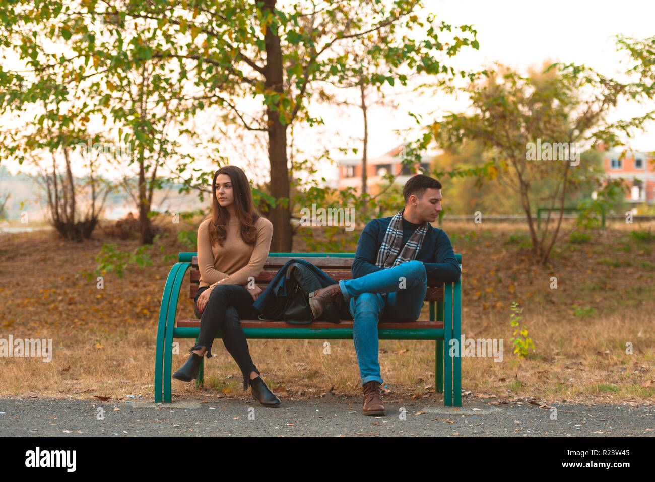 couple sitting a bench and looking opposite directions Stock Photo - Alamy