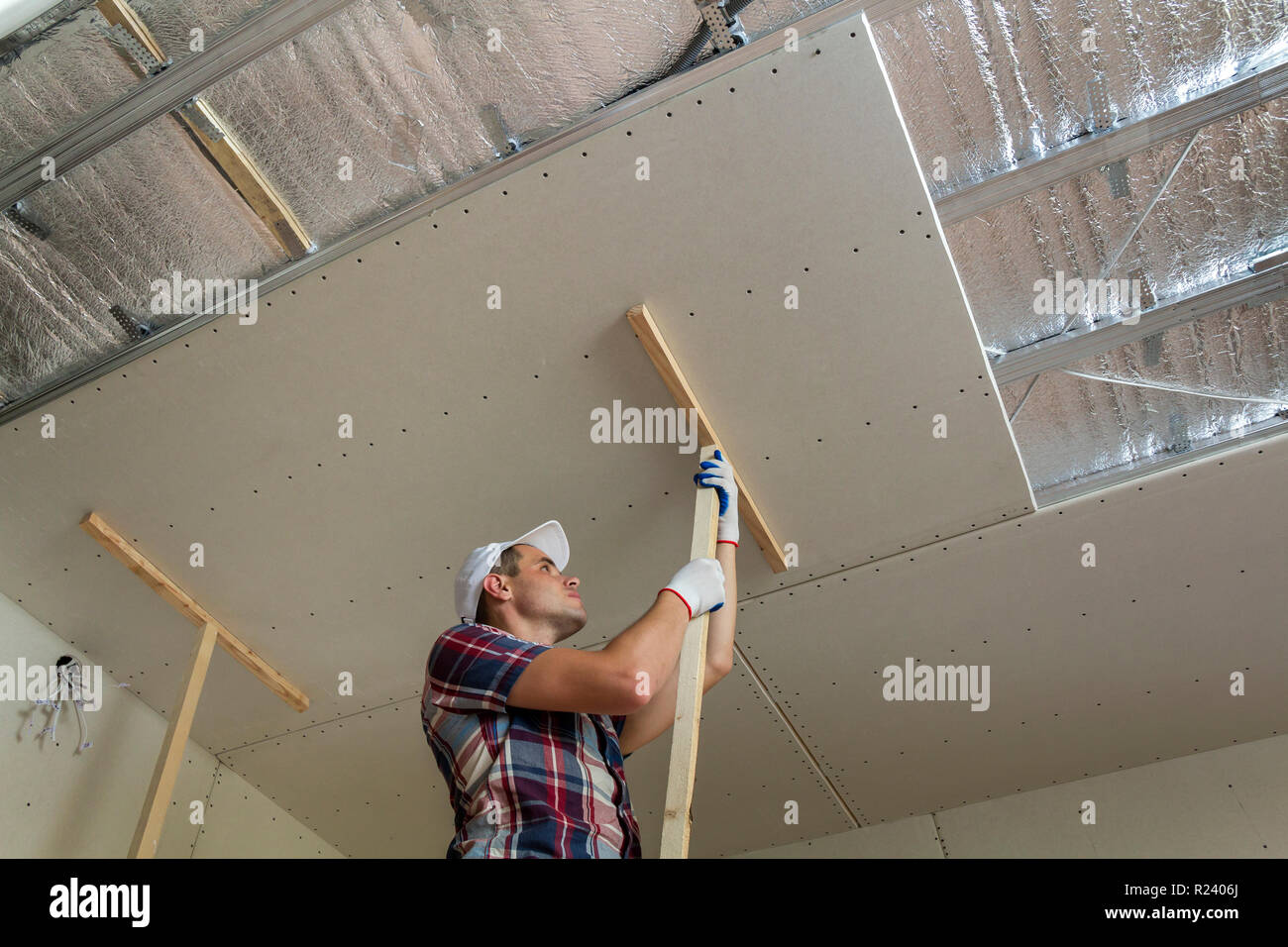 Young Worker In Protection Work Gloves Fixing Wooden Holders