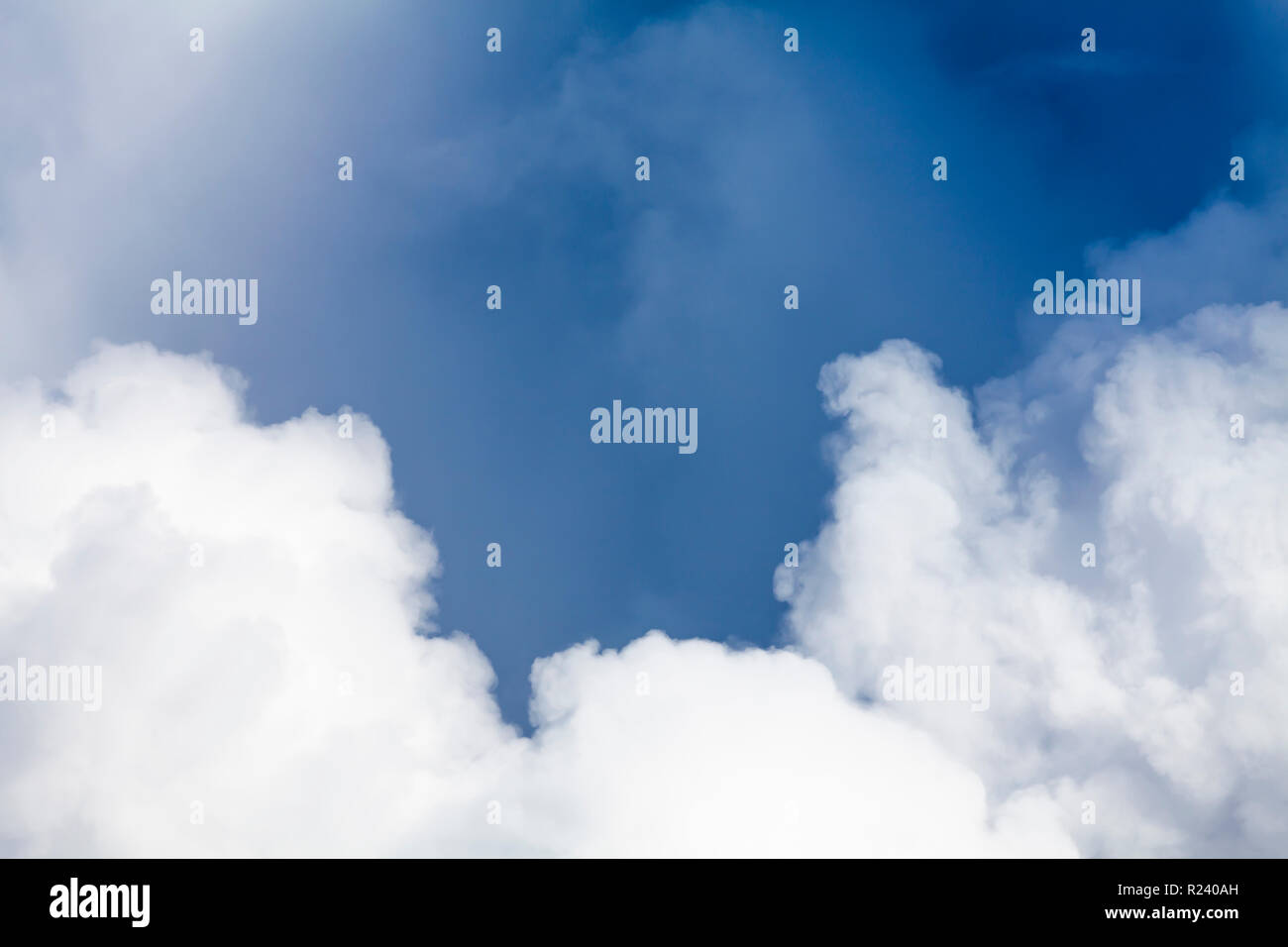 Big white puffy clouds and blue sky background. Dramatic hight detail