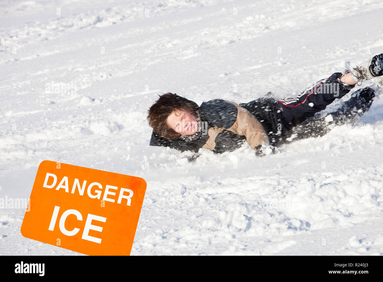 A young boy falling over in the snow, UK. Stock Photo