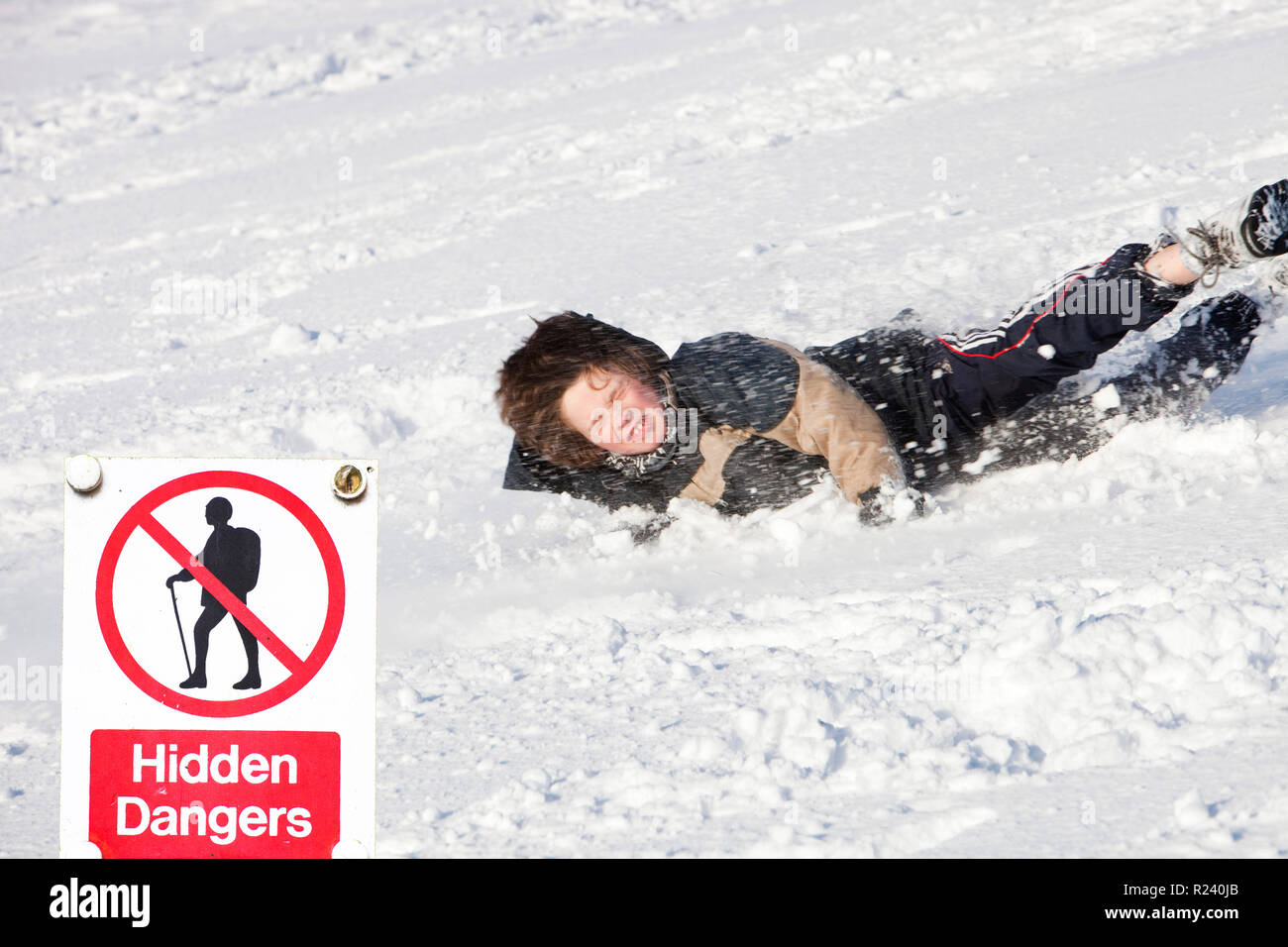A young boy falling over in the snow, UK. Stock Photo