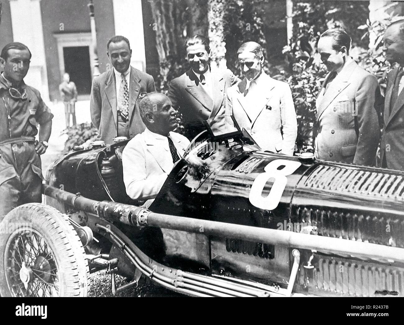 Benito Mussolini (1883-1945) Italian politician,Mussolini sits in an Alfa Romeo racing car. Looking on (centre), is Prospero Gianferrari. 1934 Stock Photo