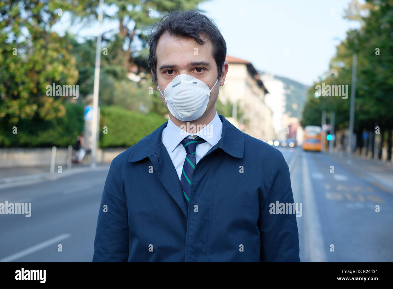 Man walking in the city wearing protection mask against smog air pollution Stock Photo