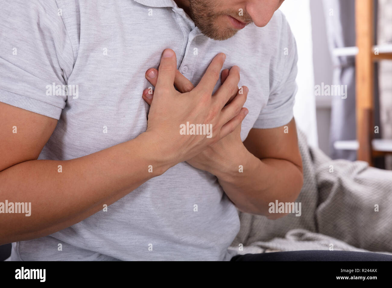 Man Touching His Chest While Suffering From Pain Stock Photo