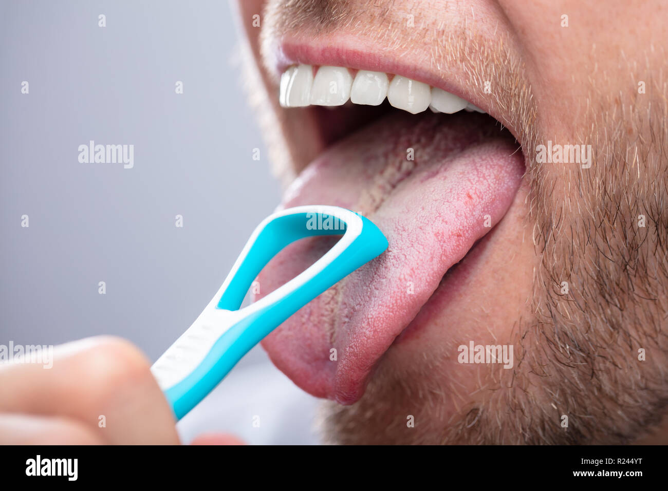 Close-up Of A Man Cleaning His Tongue With Cleaner Stock Photo