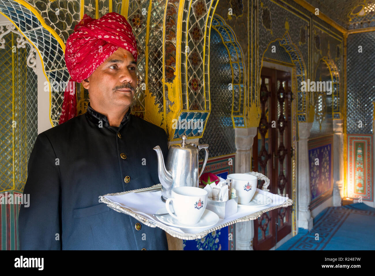 Waiter carrying tea tray in ornate passageway, Samode Palace, Jaipur, Rajasthan, India, Asia Stock Photo