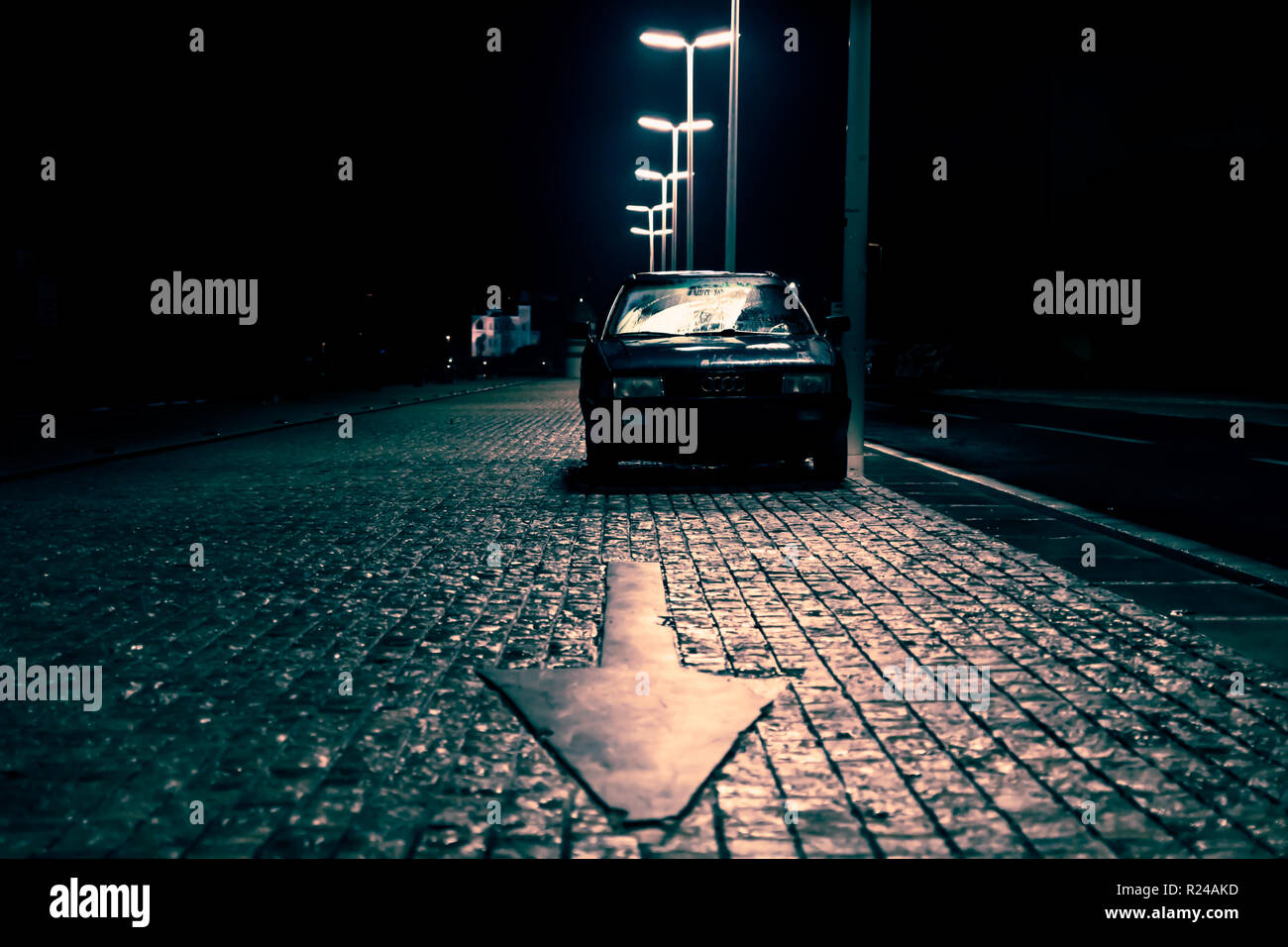 Car on cobbled street with arrow pointing in dark spooky, scary street with Audi sign, Zadar, Croatia Stock Photo