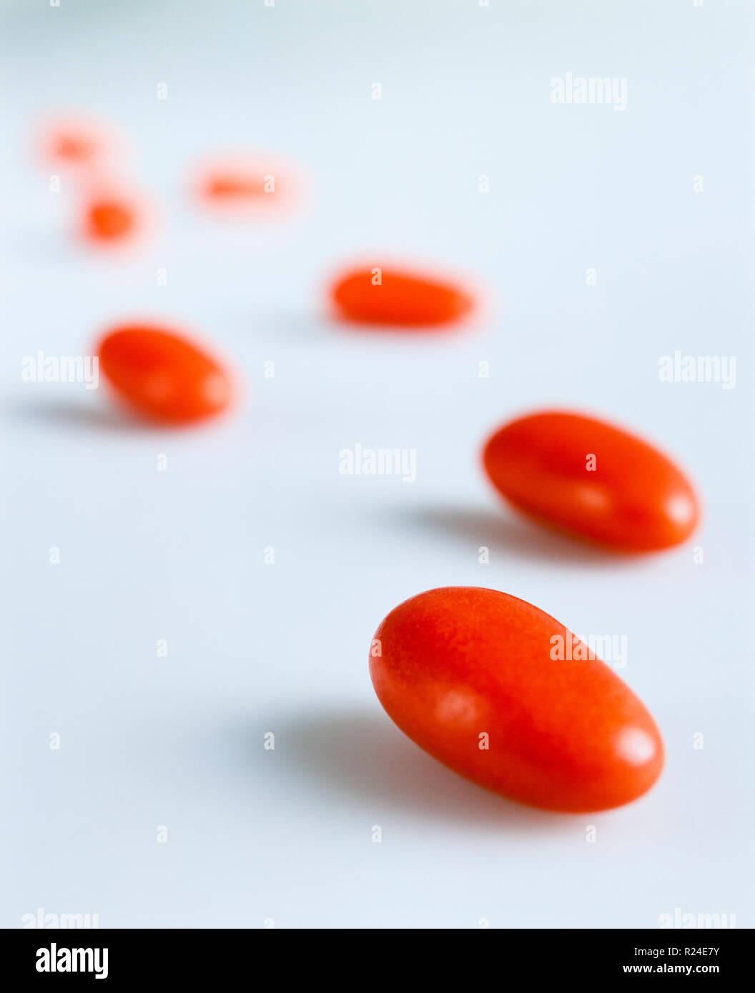 Red candy-coated almonds still life composition imitating steps Stock Photo