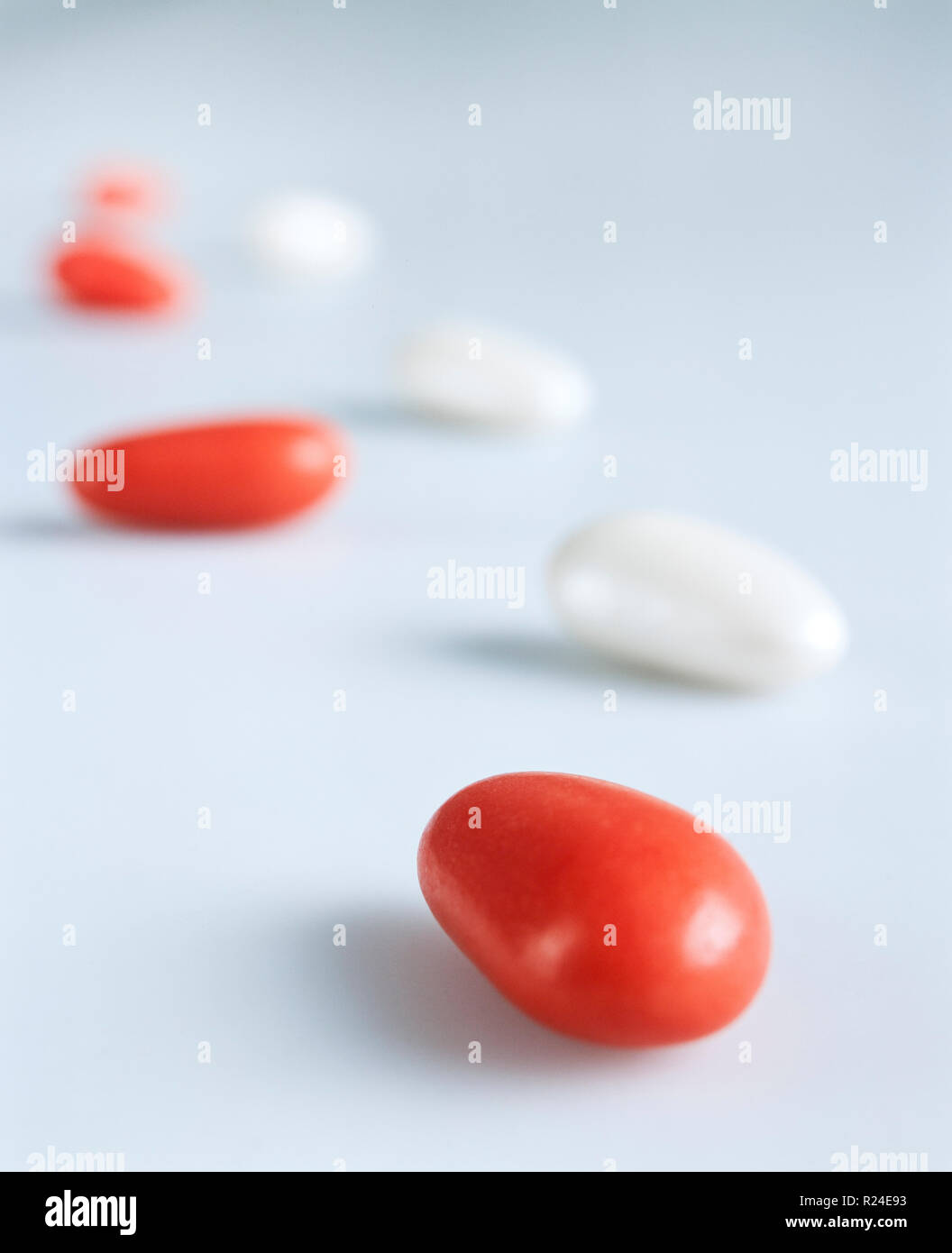 White and red candycoated almonds still life composition imitating