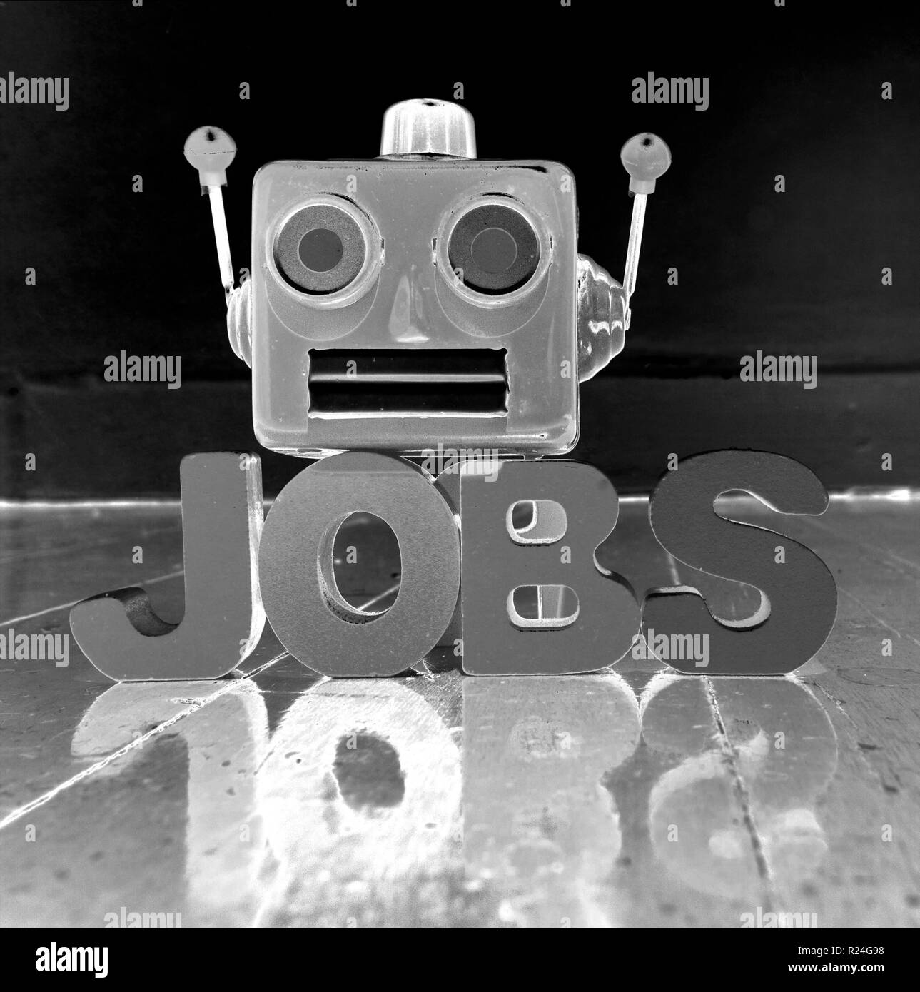 red retro robot head on the word  JOBS  on old wooden floor with reflection solarized monochrome Stock Photo