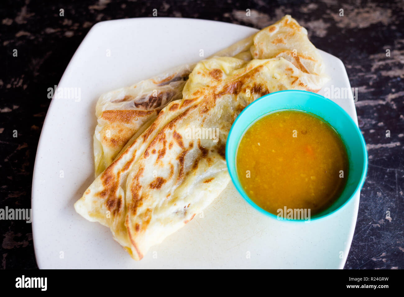 Fresh prepared malaysian roti telur pancake and dhal breakfast set served in local restaurant on Tioman island. Traditional asian cuisine made of fres Stock Photo