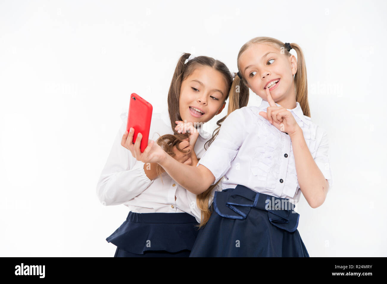 Girls school uniform take selfie smartphone. Posing to take perfect photo.  Girlish leisure. Girls just want to have fun. Schoolgirls cute hairstyle  use mobile phone or smartphone to share photos Stock Photo -