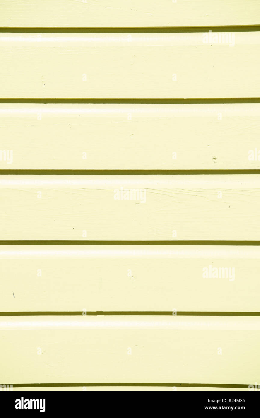 wooden clapboard background of textured siding painted in yellow color