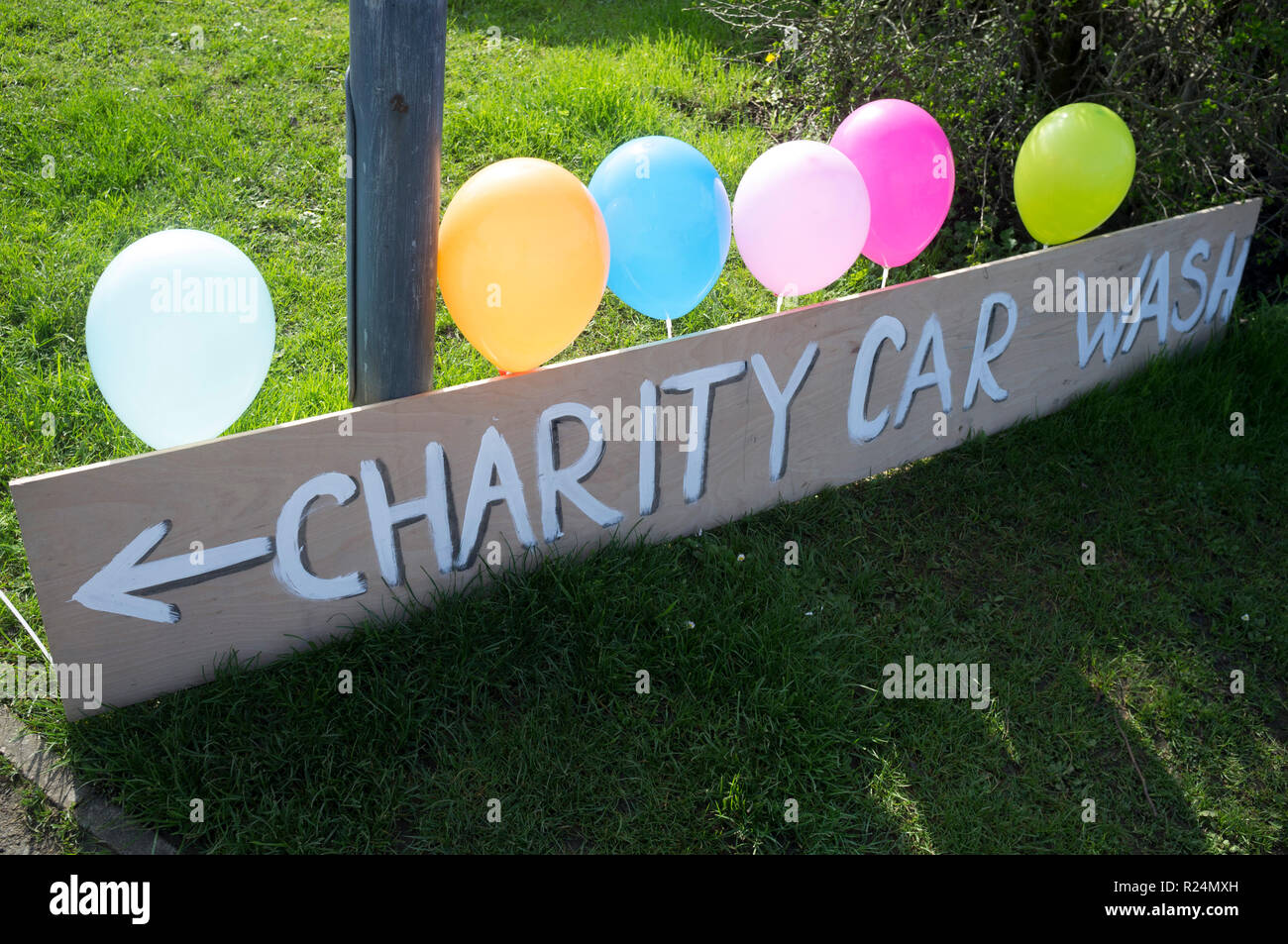 Homemade Charity Car Wash sign with brightly coloured backlit balloons Stock Photo