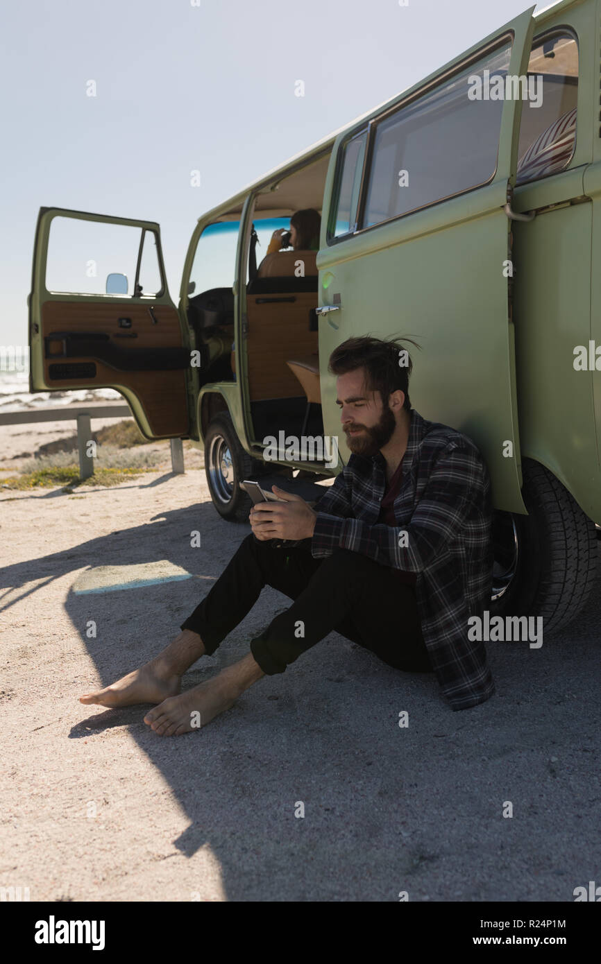 Man using mobile phone near van Stock Photo