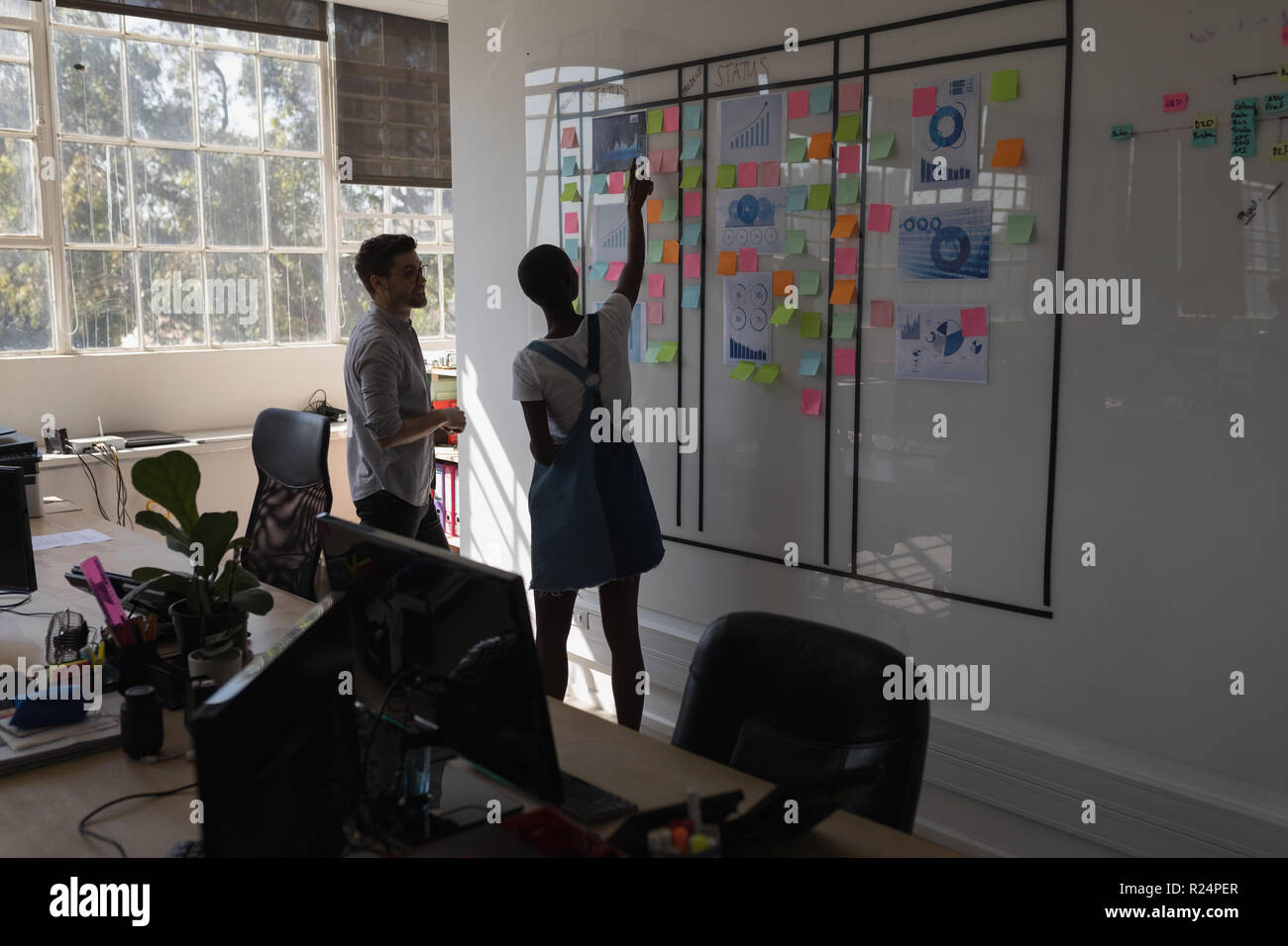 Executives discussing over sticky notes Stock Photo
