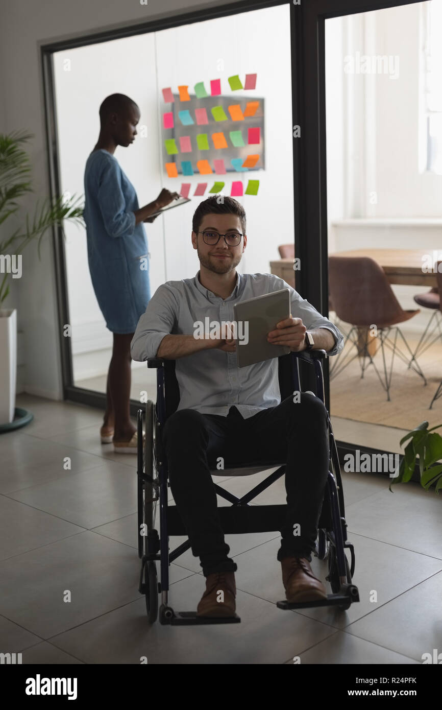 Handicap executive looking at camera while using digital tablet Stock Photo