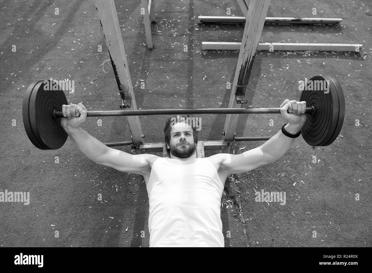 Concentrated on exercise. Man athlete training with barbell. Athletic