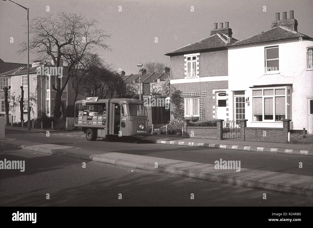 Early morning, 1970, home milk delivery, picture shows an electric milk float parked in an empty suburban street in Hadley Highstone, Barnet, London, England, UK.  In this era the majority of families had milk delivered direct to their homes but as the numbers of grocery stores and supermarkets grew, the days of the milkman were numbered. Stock Photo