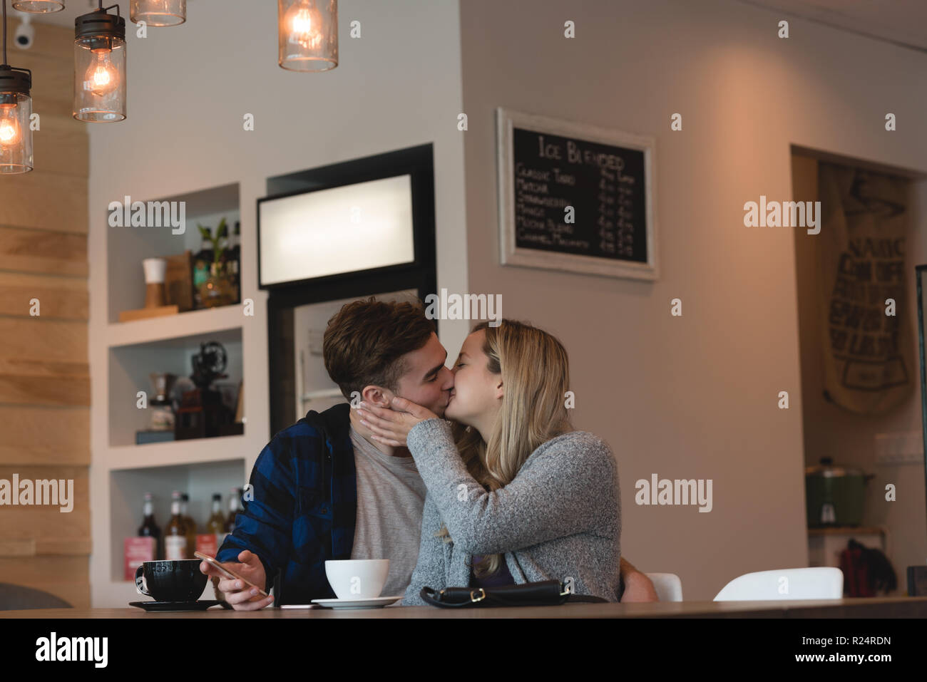 Couple kissing each other in cafe Stock Photo