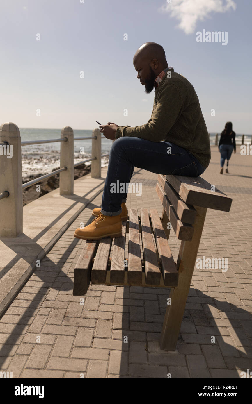 Man using mobile phone on promenade Stock Photo