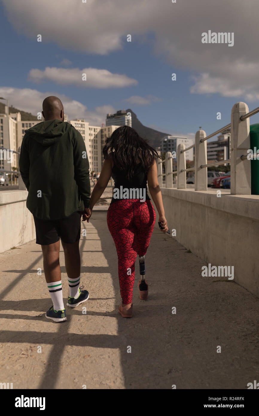Couple holding hands and walking on promenade Stock Photo - Alamy