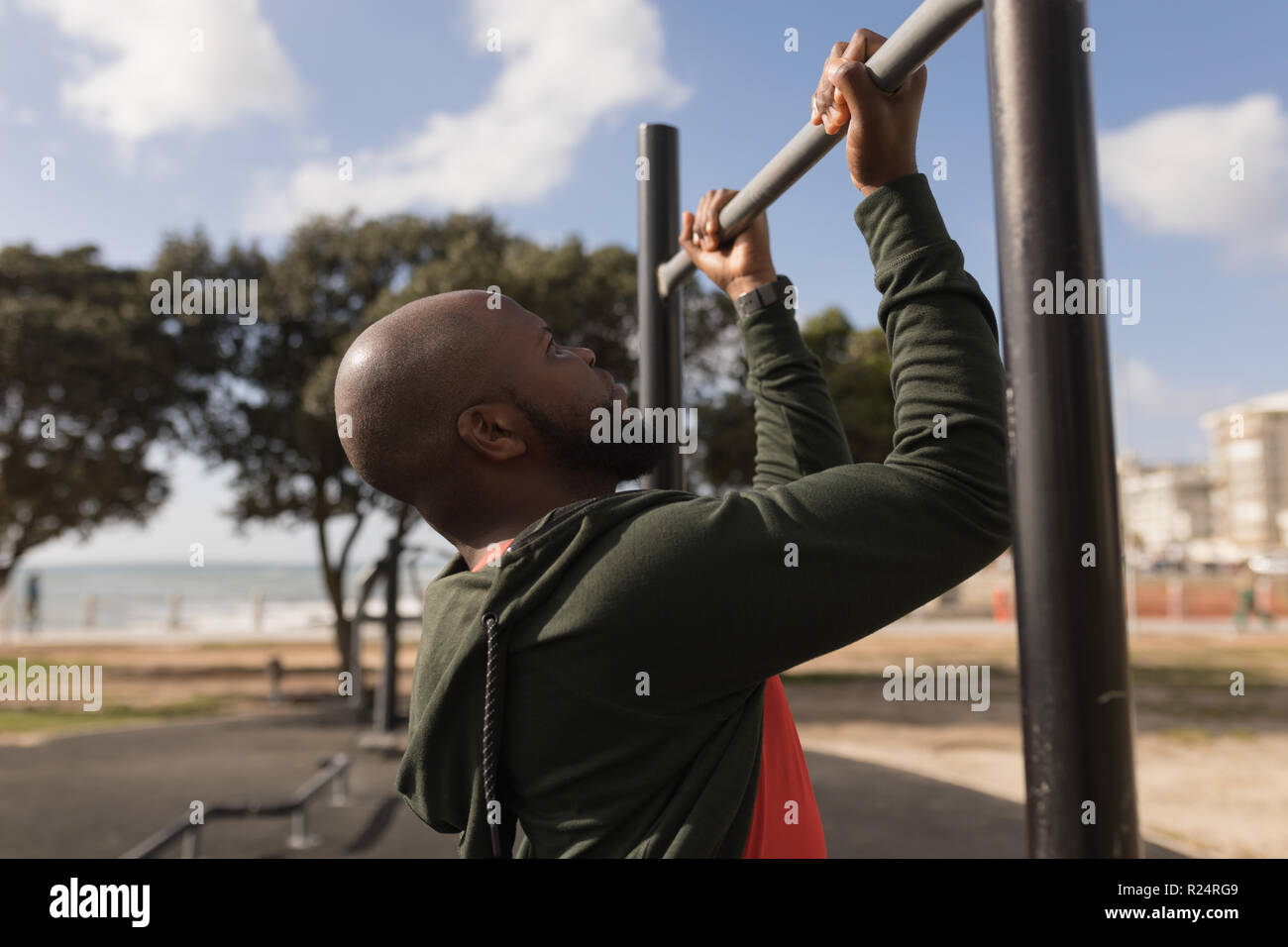 Man doing pull ups in garden Stock Photo