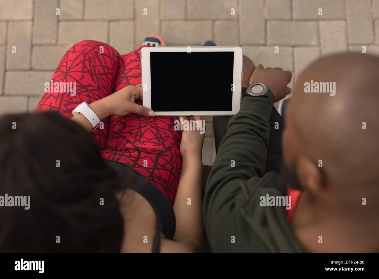 Couple using digital tablet on promenade bench Stock Photo