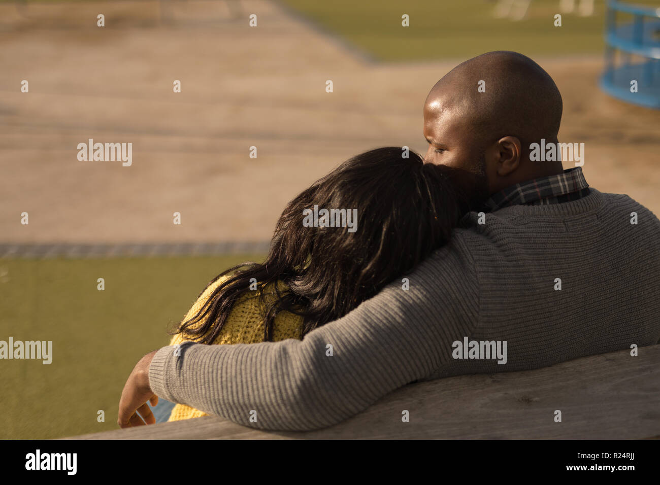 Couple sitting on bench in the park Stock Photo - Alamy