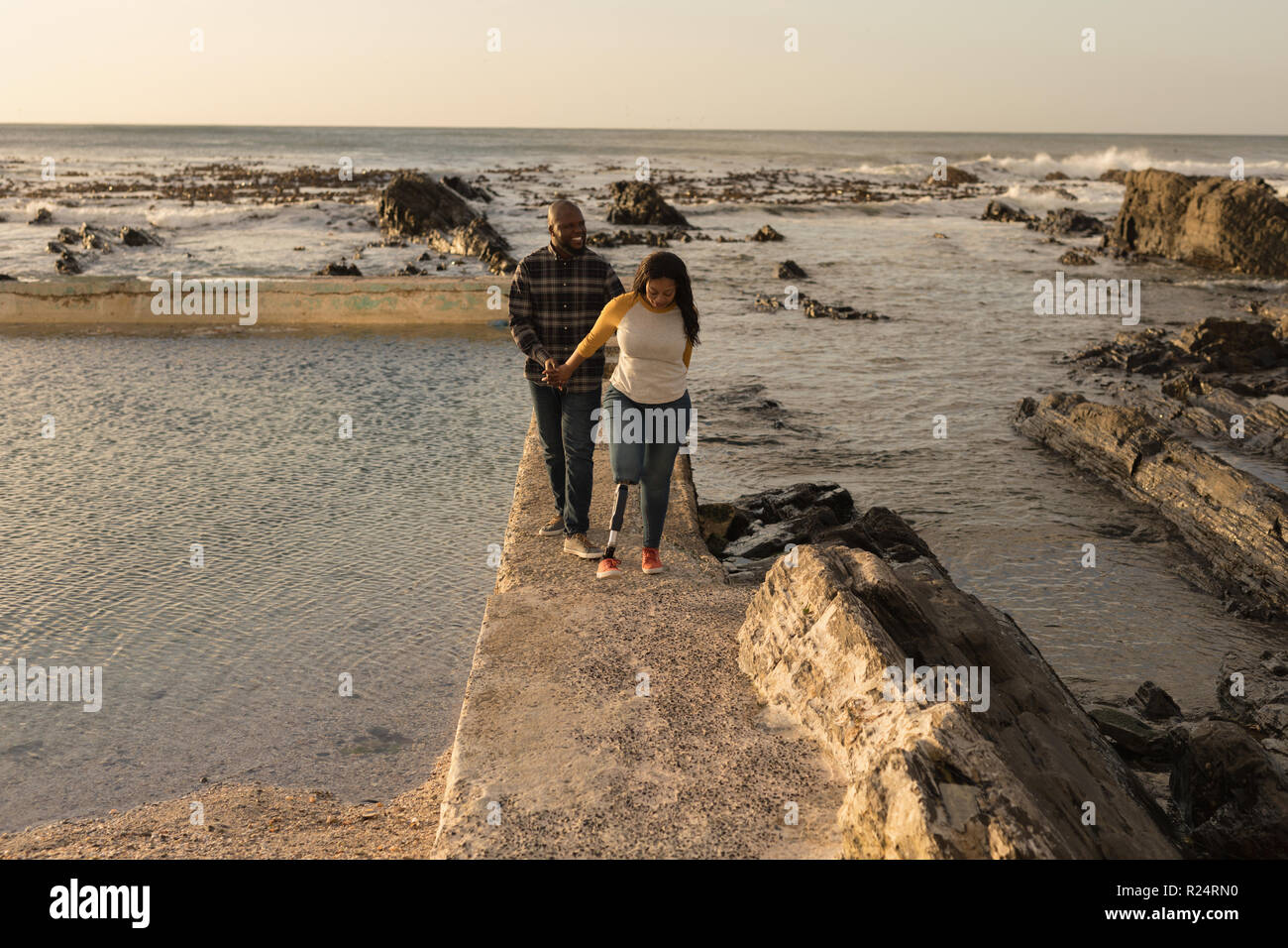 Couple holding hands and walking on promenade Stock Photo - Alamy