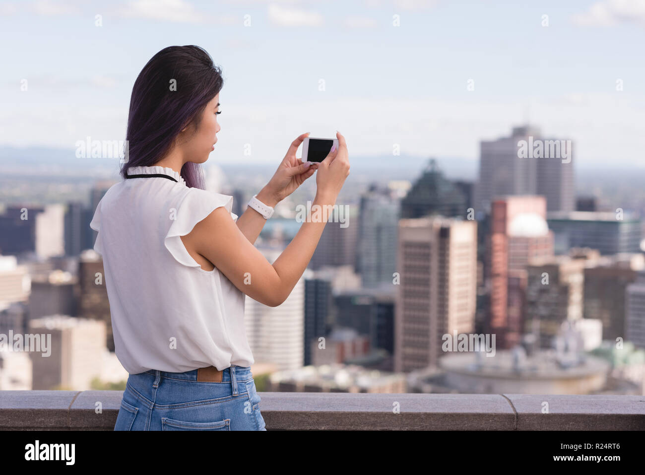 Woman clicking photo on mobile phone Stock Photo