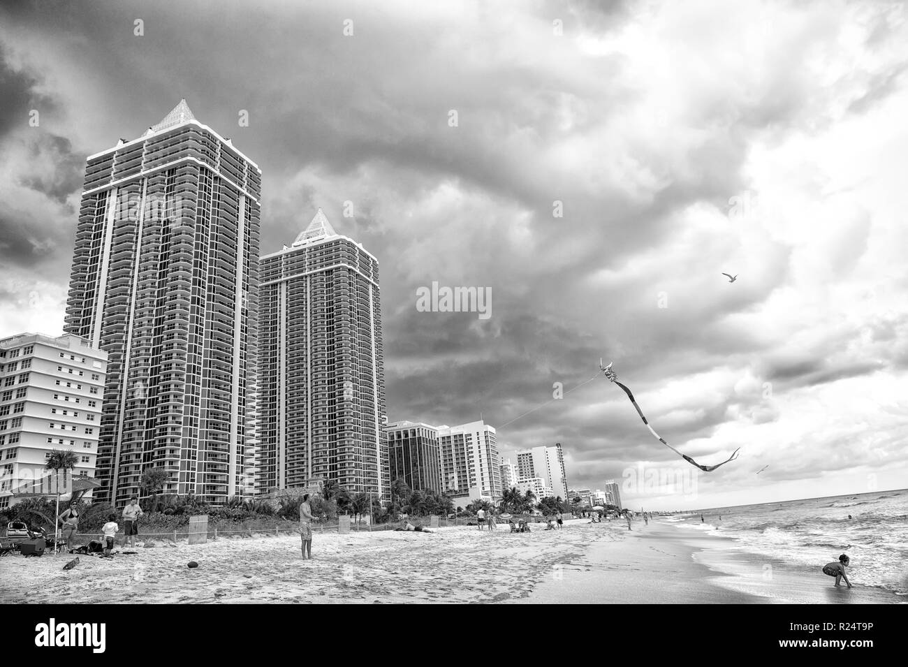 Miami, USA - January 10, 2016: sea beach and kite fly in cloudy sky. south miami beach Architecture and real estate on luxury resort. Summer vacation on sea. Wanderlust or travel. Stock Photo