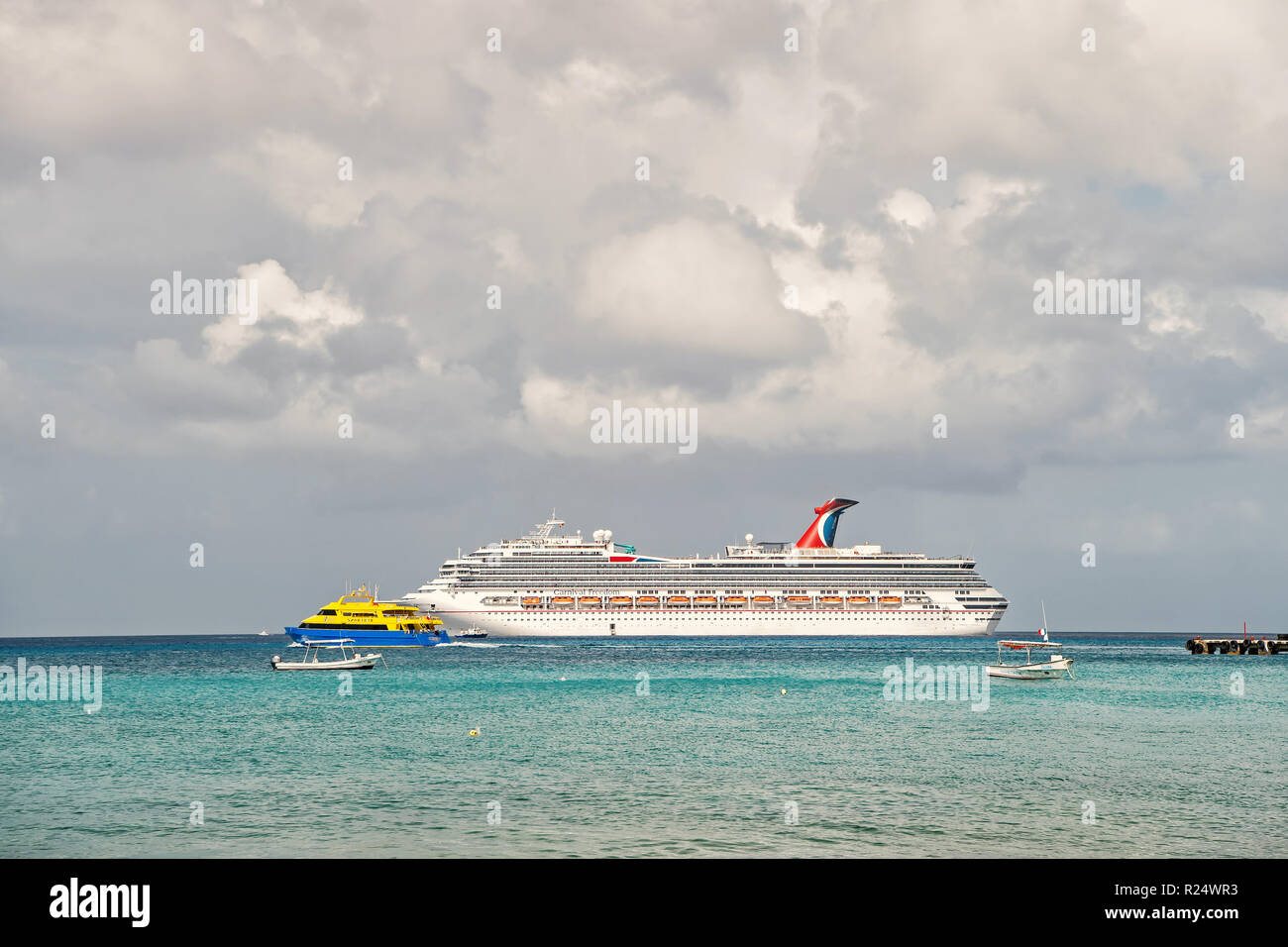 Cozumel, Mexico - December 24, 2015: large cruise ship or liner in bay or harbor, touristic passenger boat on water summer day on cloudy sky background with yachts and boats. traveling and vacation Stock Photo