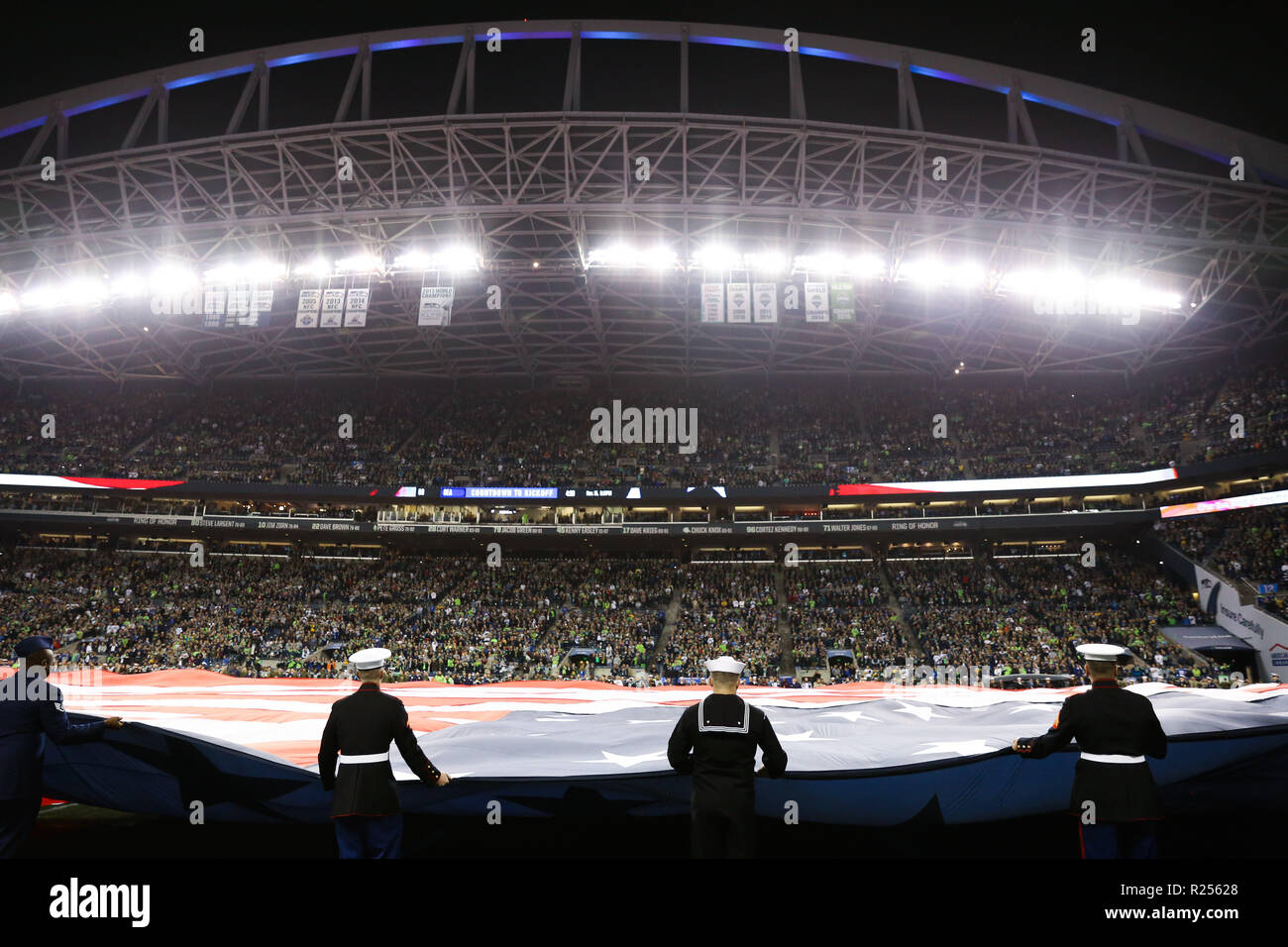 Seattle, WA, USA. 15th Nov, 2018. Members of the United States armed services hold the American flag in front of fans before a game between the Green Bay Packers and Seattle Seahawks at CenturyLink Field in Seattle, WA. Seahawks defeat the Packers 27-24. Sean Brown/CSM/Alamy Live News Stock Photo