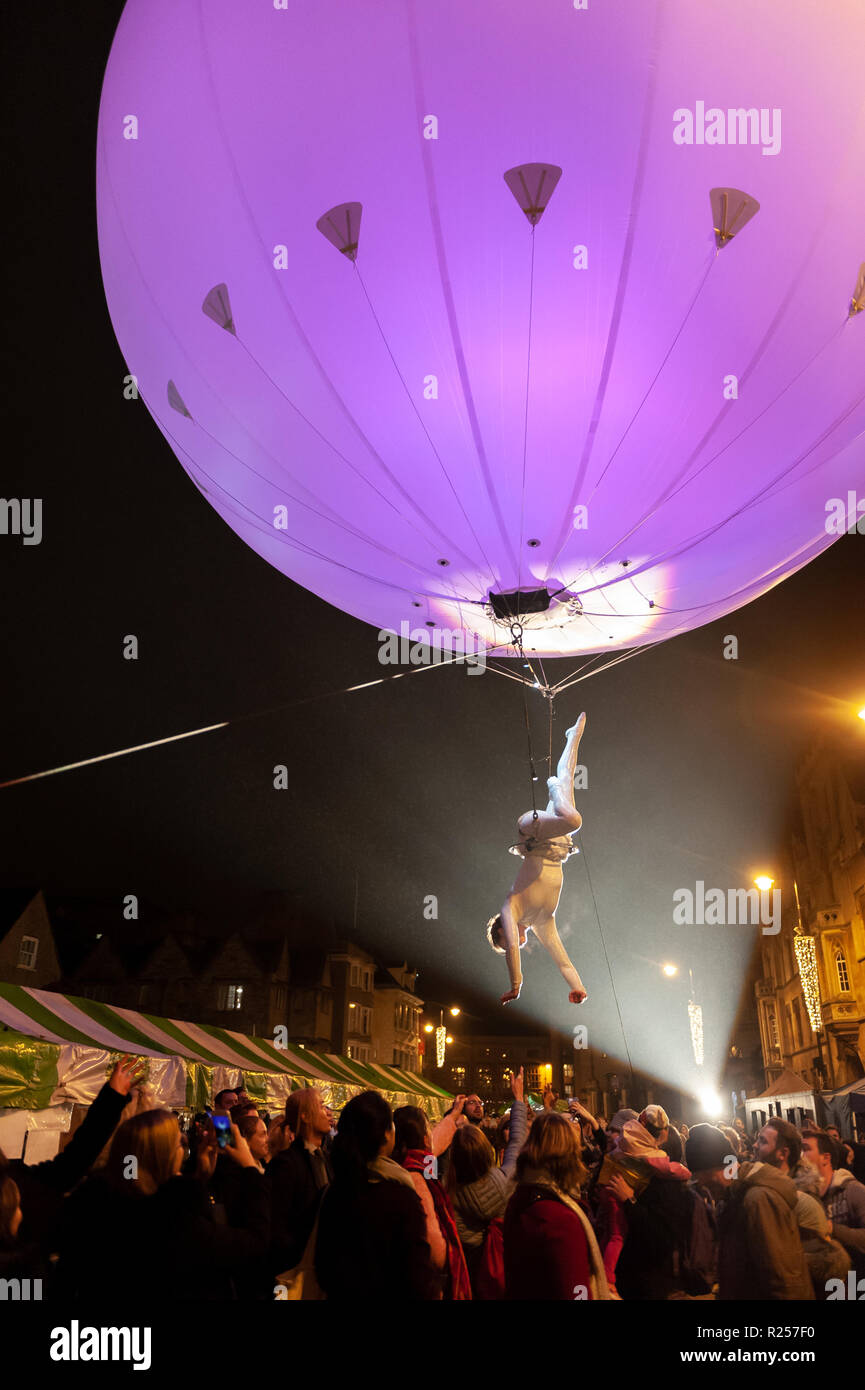 Oxford, UK. 16th November 2018. As part of Oxford's Christmas Light Festival, 'The Dream Engine' acrobat performs aerial manoeuvres under a brightly lit sphere on Broad Street. Credit: WALvAUS/Alamy Live News Stock Photo